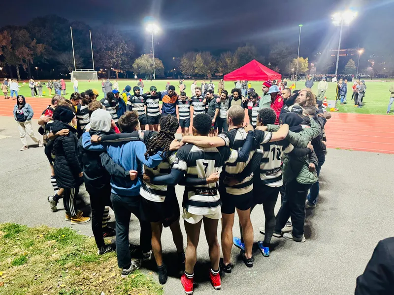 The Lions in a tight huddle under floodlights before a night match