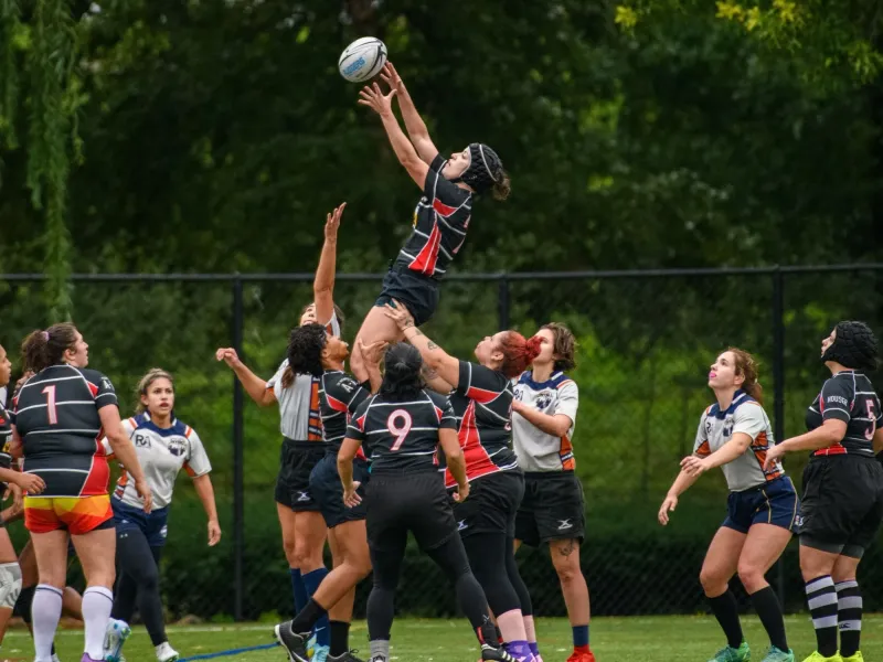 A Lions jumper takes lineout ball at full stretch, lifted by two teammates