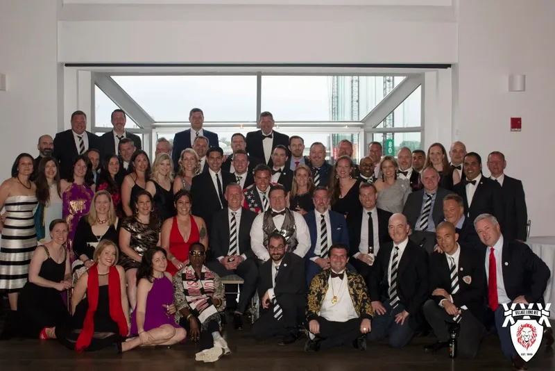 Members in black tie posed together at the 30th anniversary celebration