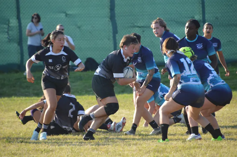 Women's+ Lions players compete at a ruck against a side in blue
