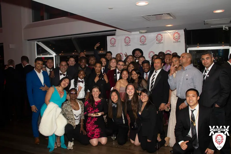 Members posed in front of a Village Lions banner at the 30th anniversary celebration